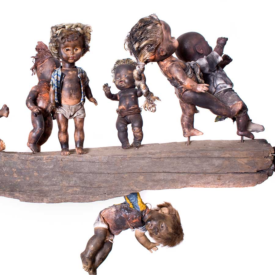 Gérard Quenum, Clandestins (Stowaways), 2009. Wood, metal and plastic dolls, 151 x 405cm